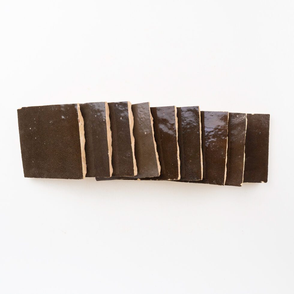 Row of dark brown square zellige tiles on a white background. Made in Morocco.