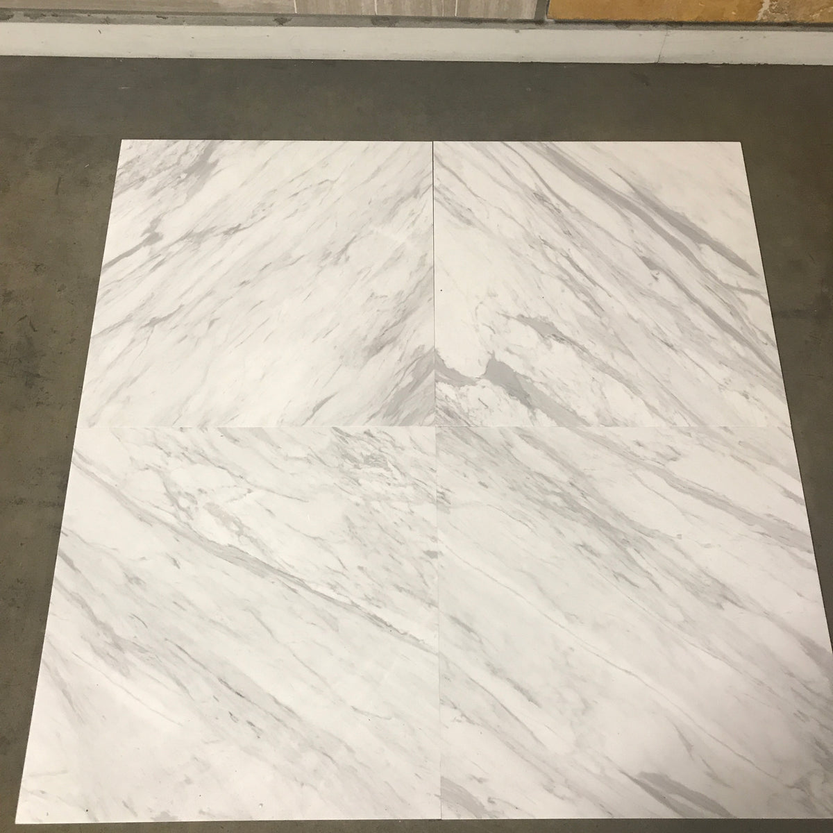 Calacatta Supreme 24×24×¾ polished marble showing a white field and gray mineral movement.