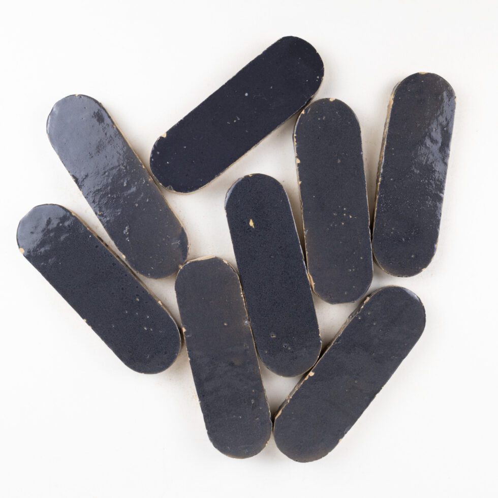 Indigo blue oval-shaped zellige tiles on a white background
