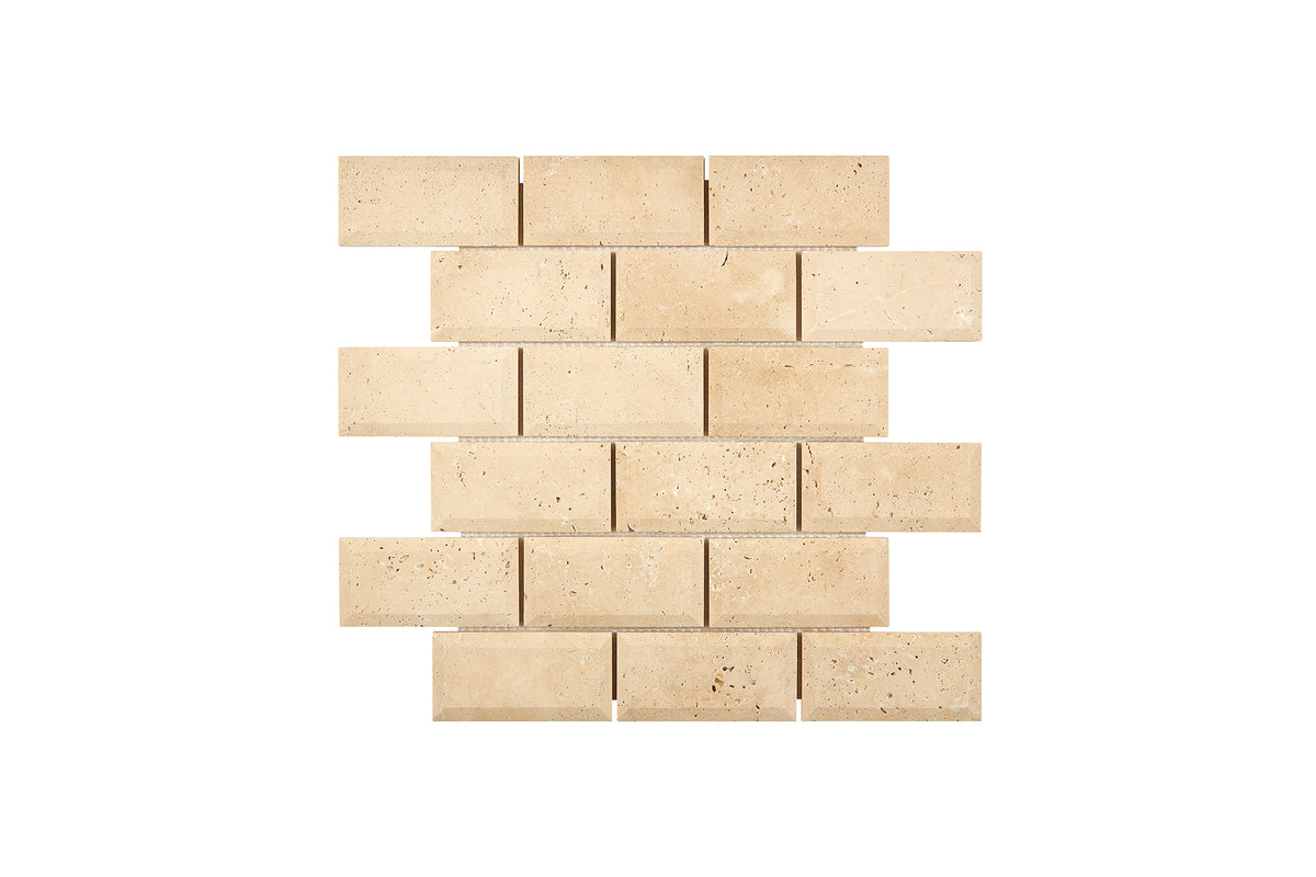 Ivory Travertine 2×4 deep-beveled mosaic sheet in a honed finish, warm ivory-beige natural stone.