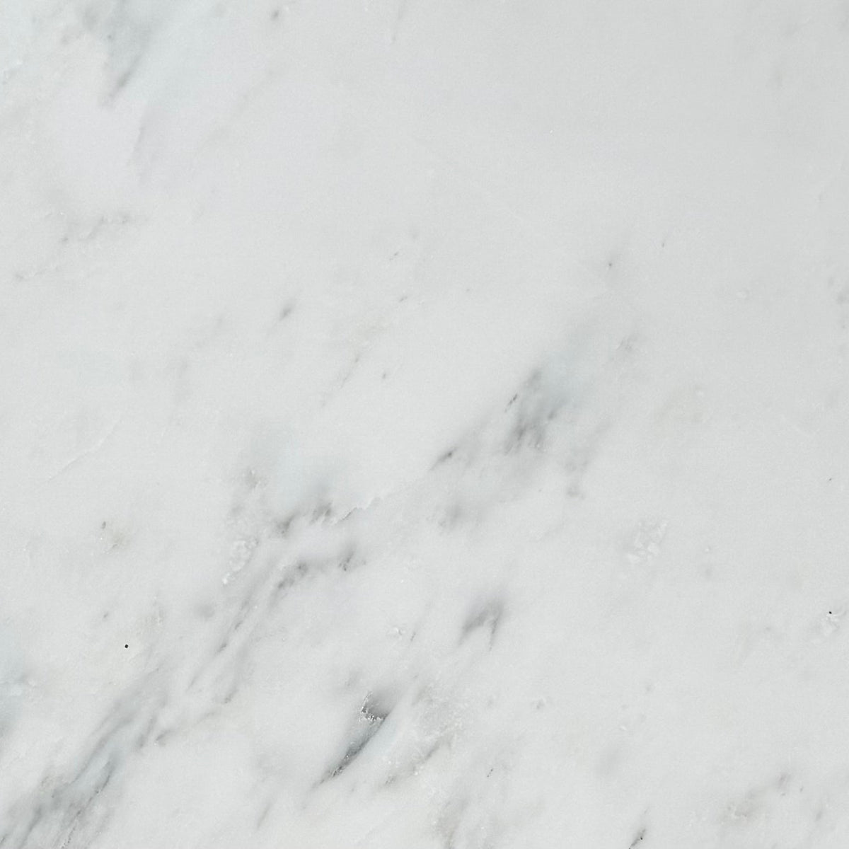 Oriental White marble 4×4 tile close-up, bright white stone with soft gray veining.
