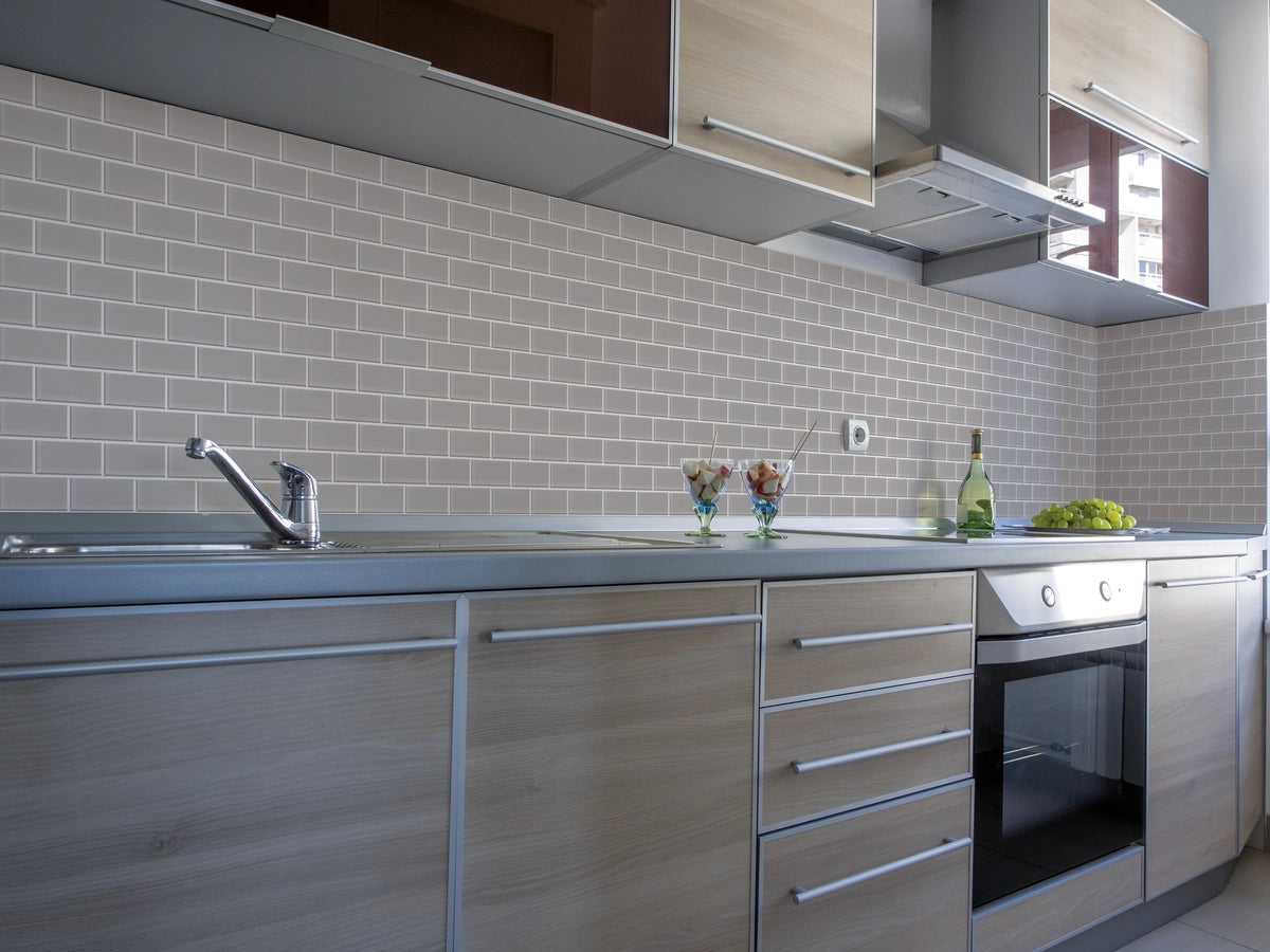 Radiant Surfaces Ash Gray glossy 3×6 glass subway tile on a kitchen backsplash.