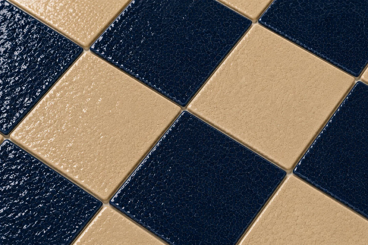 Close-up of Geneviève glossy Zellige checkerboard showing handmade glaze and edge variation, Indigo & Sand.
