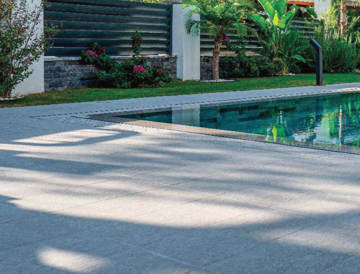 Cement Grey porcelain pool deck tile around a residential pool, project example
