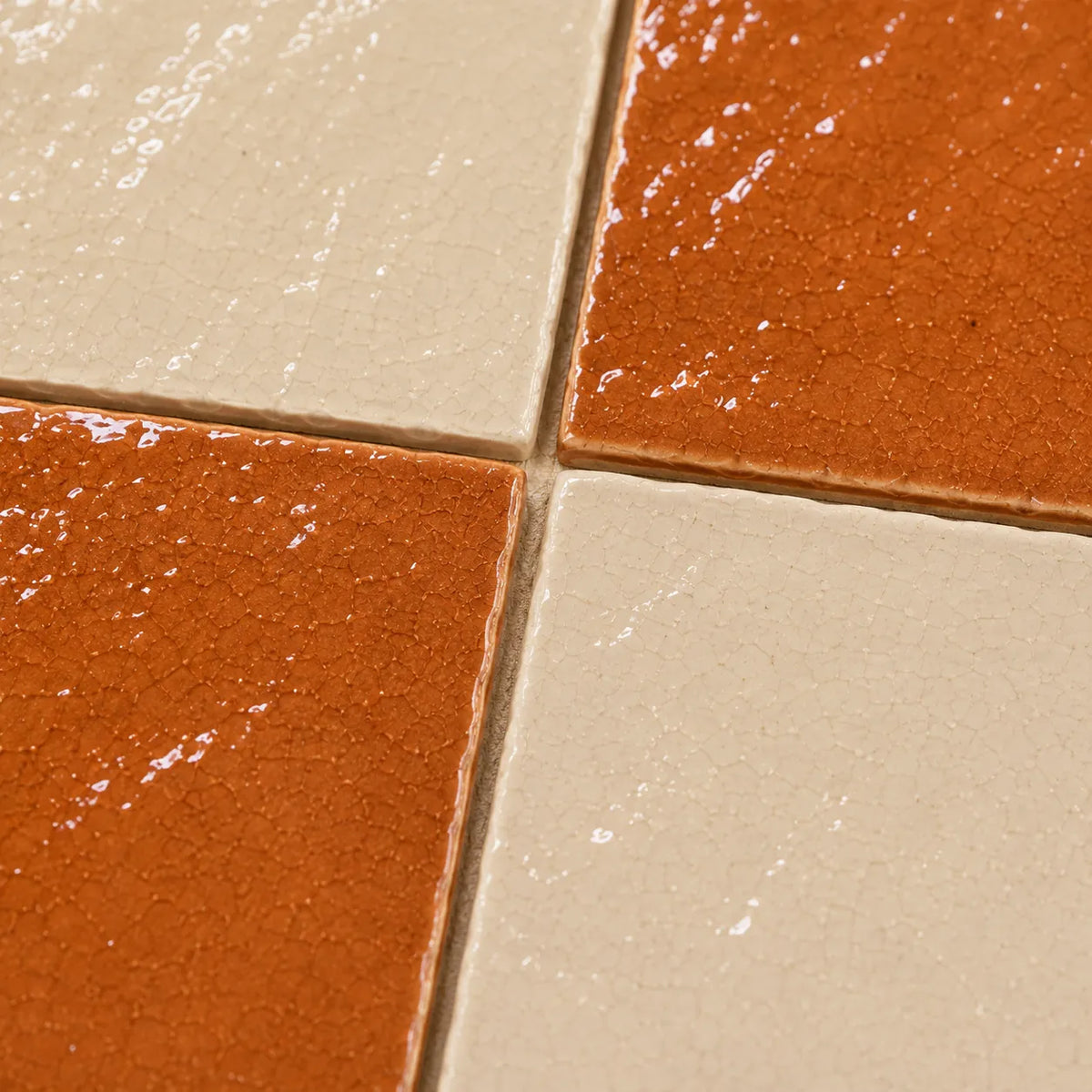 Close-up of Solenne glossy Zellige checkerboard showing handmade glaze and edge variation, Terracotta & Ivory.
