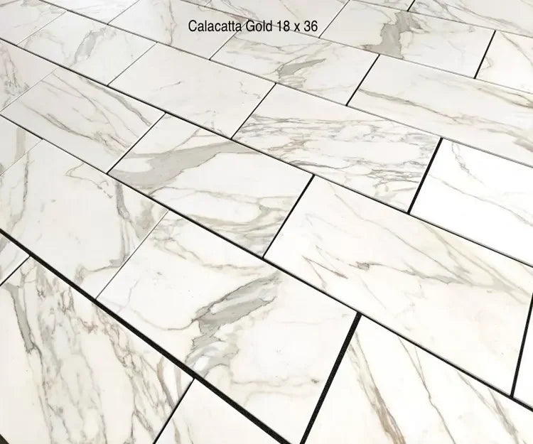 Calacatta Gold 18x36 large format marble tile with dramatic gray veining in a staggered floor layout.