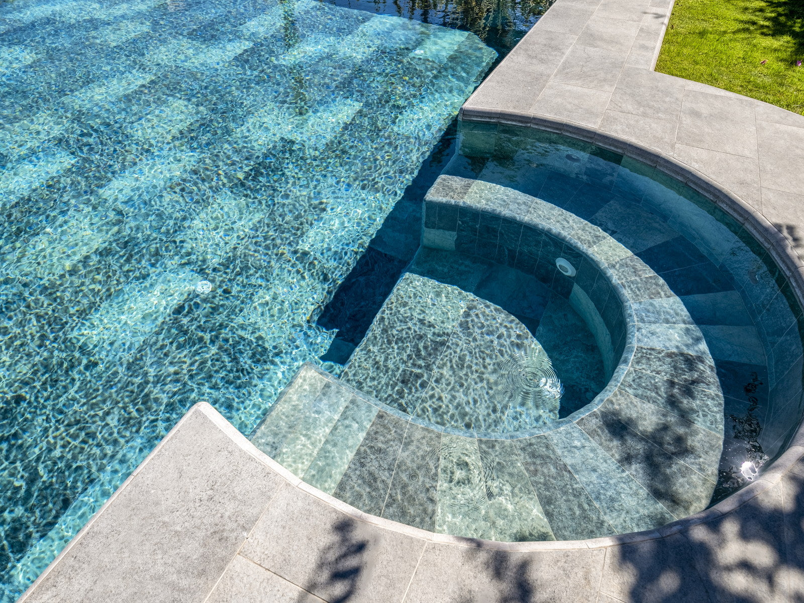 Luxury swimming pool featuring coordinated Serapool Relax porcelain pool tile, coping, and, outdoor surfaces