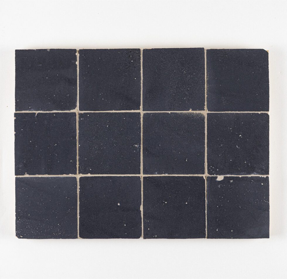 Dark blue zellige tiles arranged in a grid pattern on a white background
