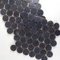Close-up of dark blue circular zellige mosaic tiles arranged in a pattern on a white background