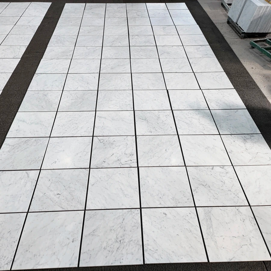 Carrara White Gioia marble 24×24 tiles dry-laid for natural color and veining selection.
