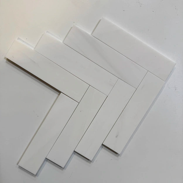 Bianco Dolomite 2×8 inches marble subway tile in a herringbone layout.