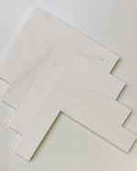 Bianco Dolomite marble tiles with a honed surface, arranged in a geometric pattern, perfect for kitchen or bathroom designs.
