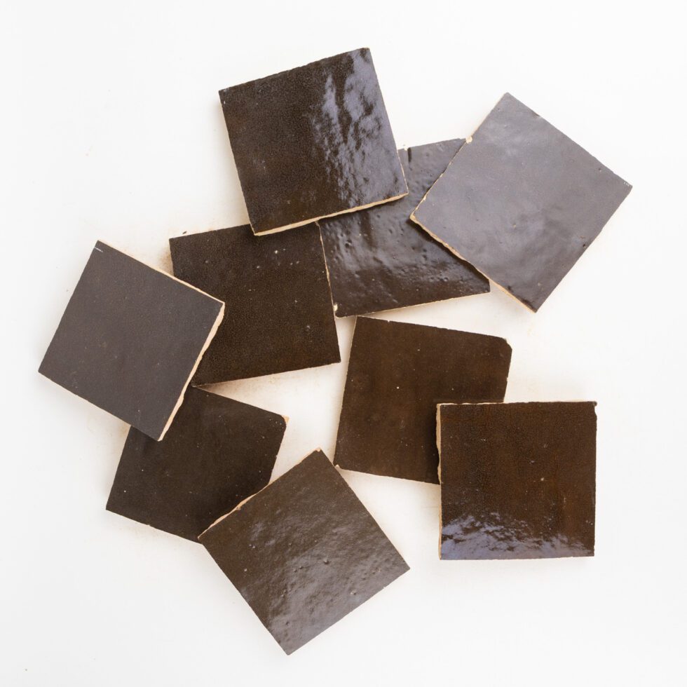 Dark brown square hand-made zellige tiles on a white background