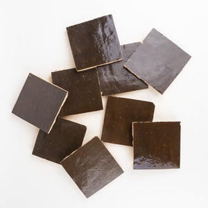 Dark brown square hand-made zellige tiles on a white background