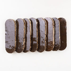 Row of zellige tiles with a glossy finish on a white background