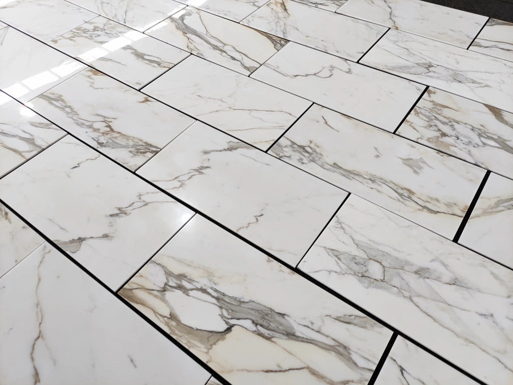Calacatta Gold 18×36 inches marble tile with natural white, gray, and gold veining.