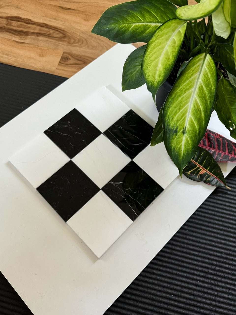 A geometric layout of black Nero Marquina marble and white Bianco Dolomite marble arranged in a checkered pattern. This combination provides a timeless and sophisticated touch to bathrooms, kitchens, or entryways.