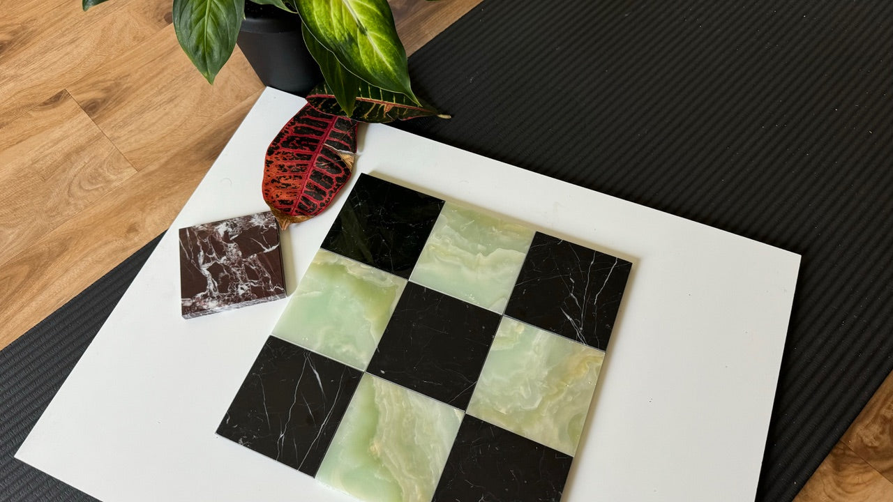 A dynamic checkerboard tile design featuring Nero Marquina marble and Green Onyx tiles. The contrasting colors and polished finish of the tiles create a sophisticated and bold look, perfect for high-end interior design.