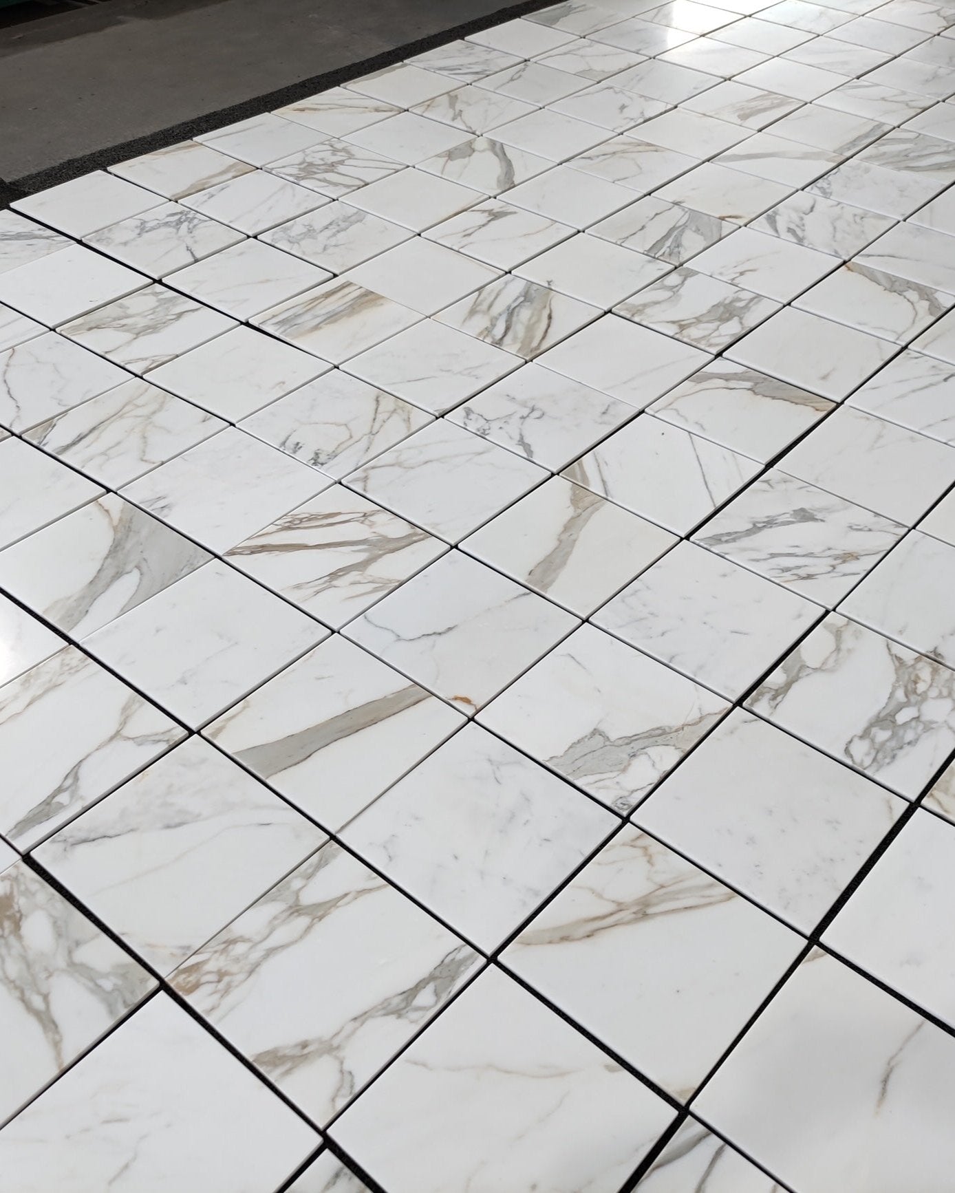 Calacatta Gold marble tile 12x12 with gold veining, available in honed or polished finish
