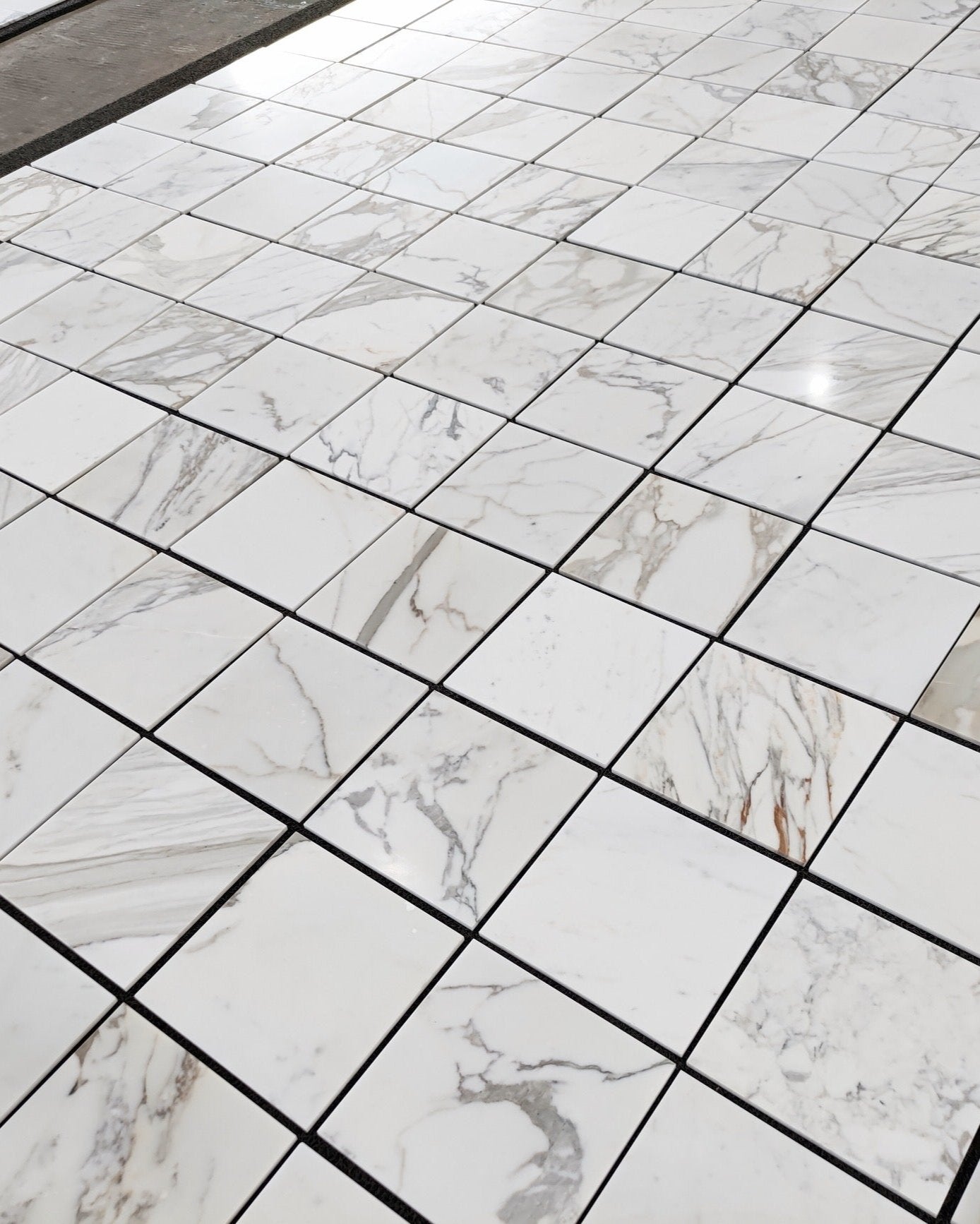 Calacatta Gold 12x12 marble tile with luxurious gold veining, perfect for high-end interiors. Available in honed or polished finish for sophisticated style.