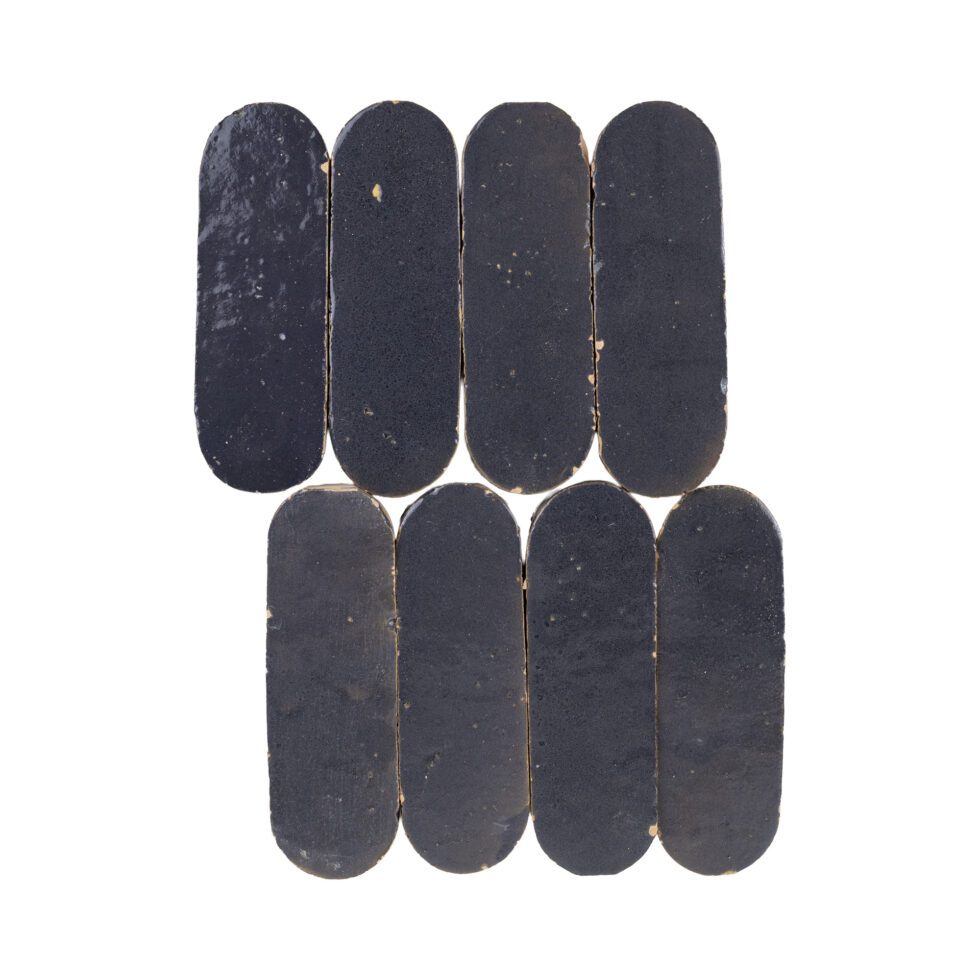 Indigo color oval-shaped zellige mosaic tile chips on a white background