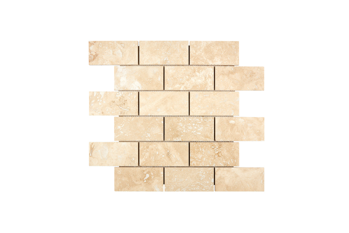 Ivory Travertine 2×4 brick mosaic sheet in a honed and filled finish, warm ivory-beige natural stone.