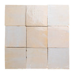 Nine square zellige tiles in beige and white on a white background