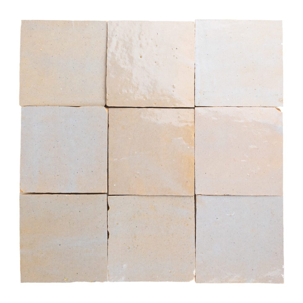 Nine square hand-made zellige tiles in beige and white on a white background
