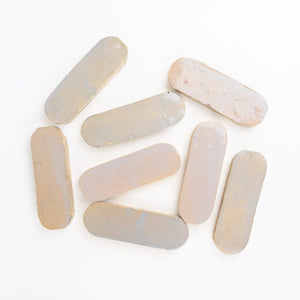 White-pink oval-shaped zellige mosaic tile chips on a white background