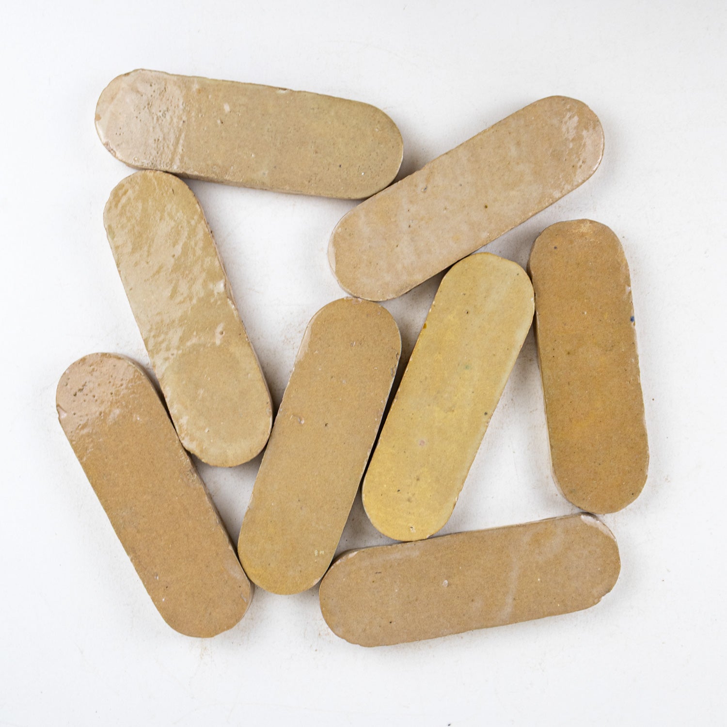 Brown - amber color oval-shaped zellige tiles on a white background