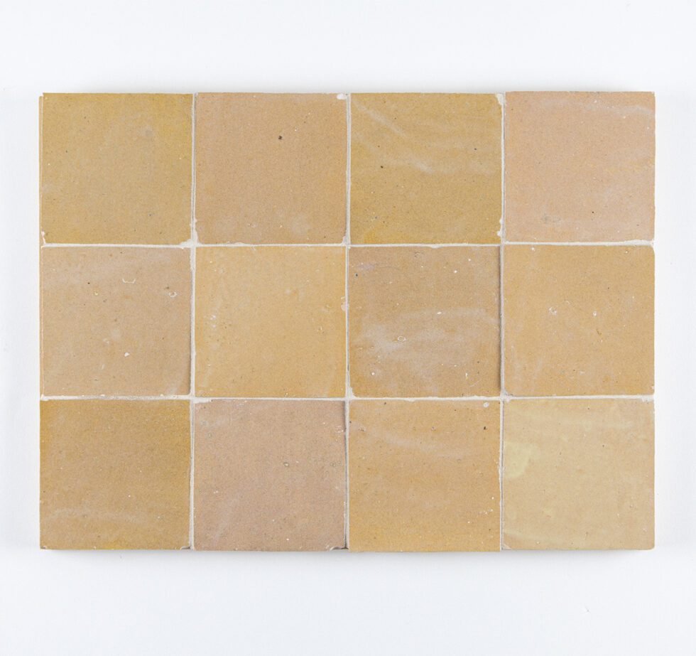 Set of amber-gold color zellige tiles on a white background
