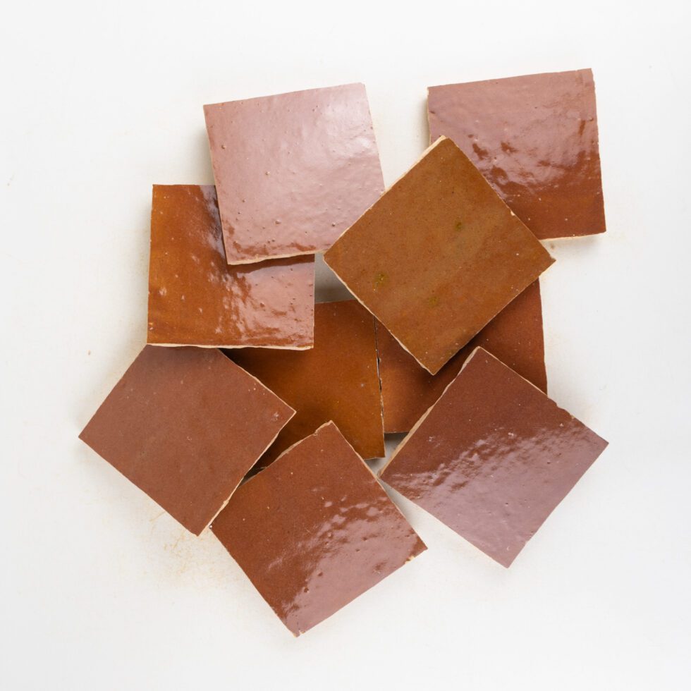 Chocolate brown zellige tiles stacked on a white background