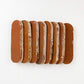 Row of oval shaped brown terracotta color zellige tiles on a white background