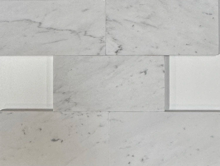 Close-up of White Carrara marble tiles with soft veining, highlighting their luxurious appearance and durable surface.