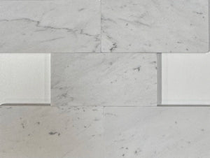 Close-up of White Carrara marble tiles with soft veining, highlighting their luxurious appearance and durable surface.