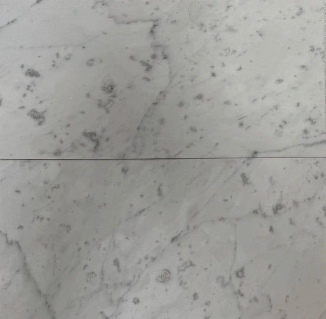 6x12 Carrara marble tiles with honed and polished options, showcasing subtle veining and a luxurious white surface for versatile applications.