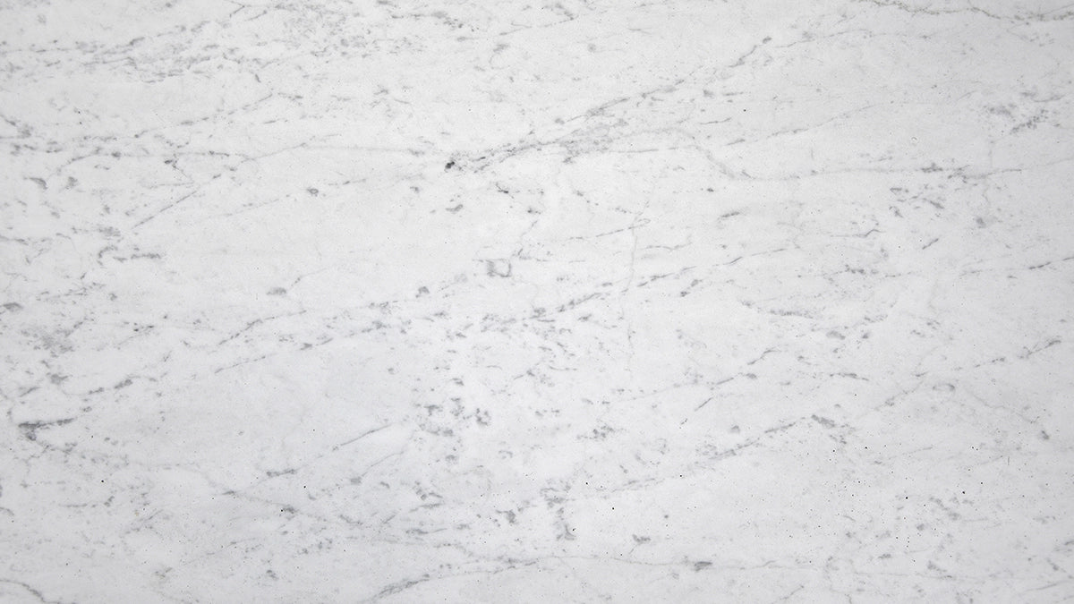 White Carrara Gioia marble large format tiles with a soft white background and subtle grey veining, showcasing a classic and refined look ideal for both modern and traditional spaces. Perfect for countertops, wall cladding, and floor applications