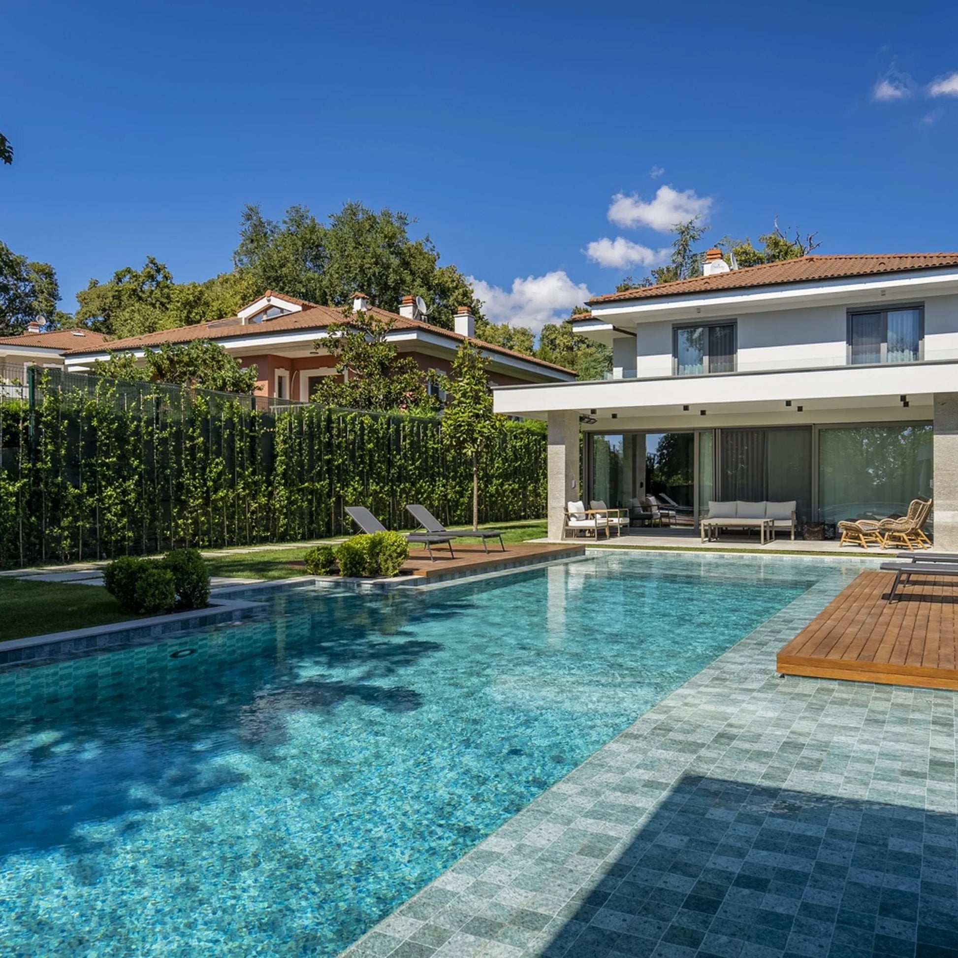 SeraPool Modern pool patio with Relax porcelain pool tile and gray poolside pavers in daylight