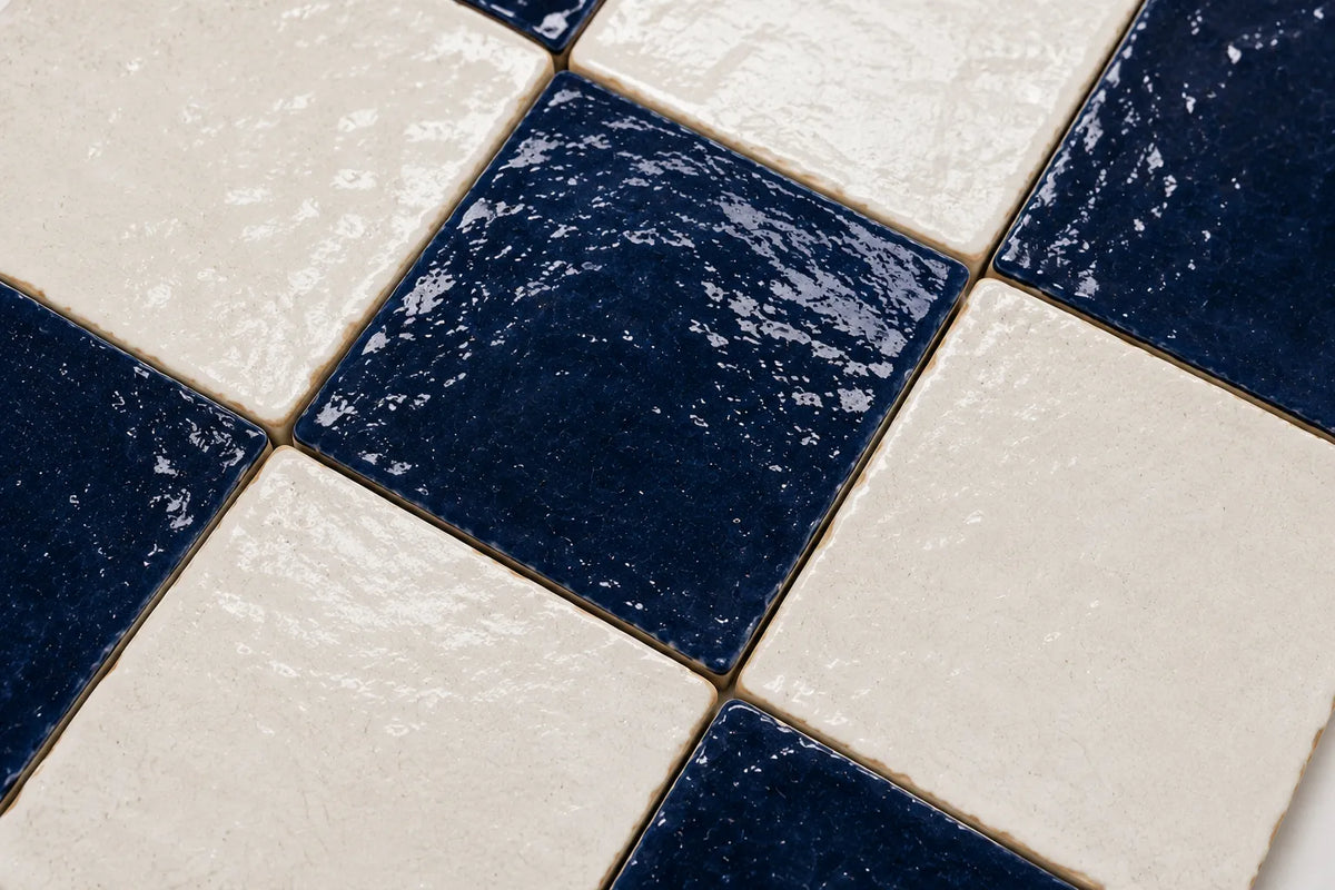 Close-up of Camille glossy Zellige checkerboard showing handmade glaze and edge variation, Indigo & Ivory.