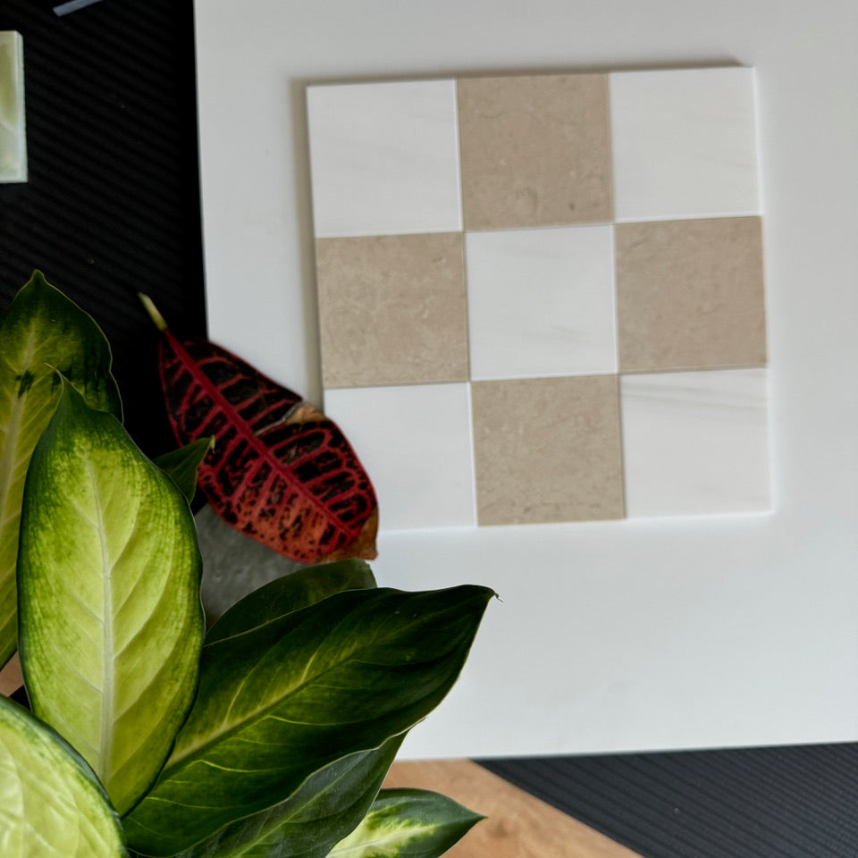 An elegant checkerboard tile pattern composed of Crema Marfil and Bianco Dolomite tiles, with lush green leaves adding a fresh, natural touch. Ideal for high-end kitchen backsplashes and bathroom flooring