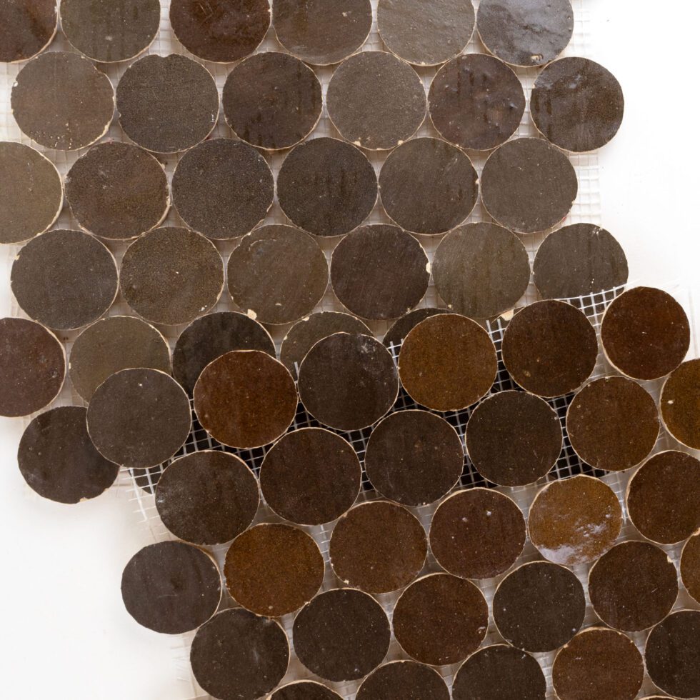 Close-up of brown circular zellige tiles with a white background