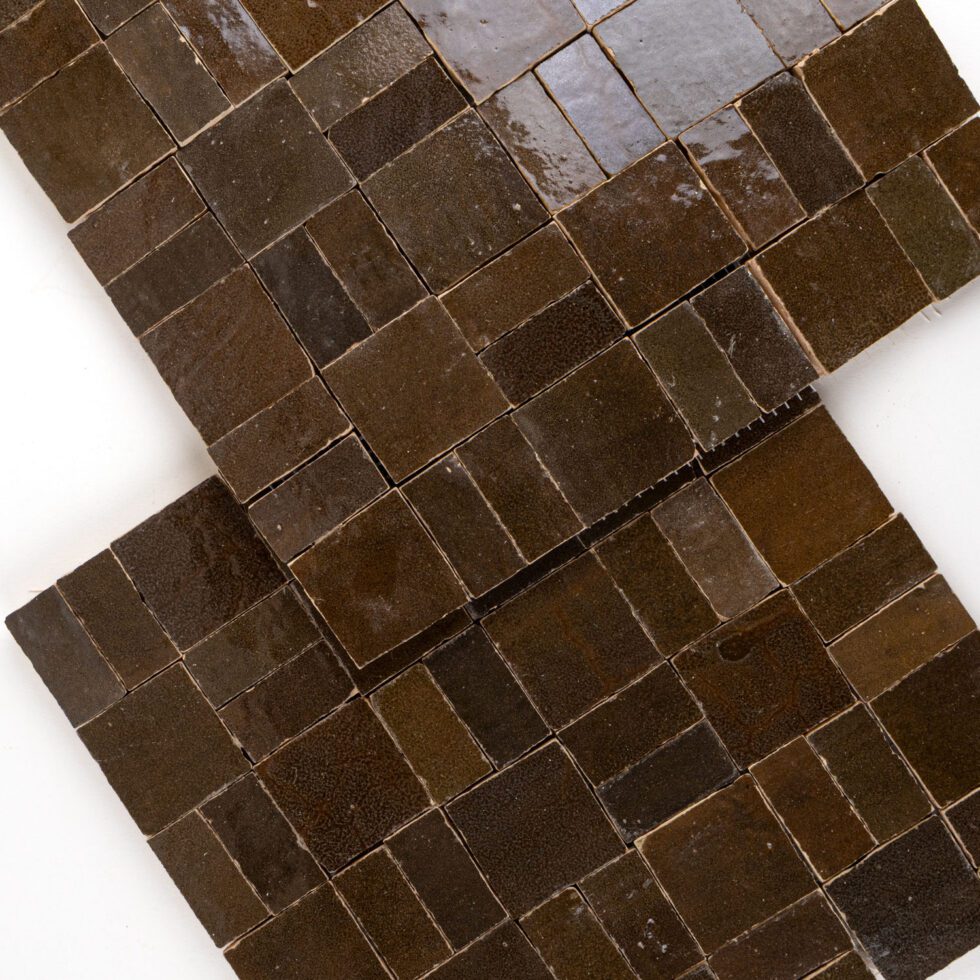 Brown square zellige mosaic tiles arranged in a pattern on a white background
