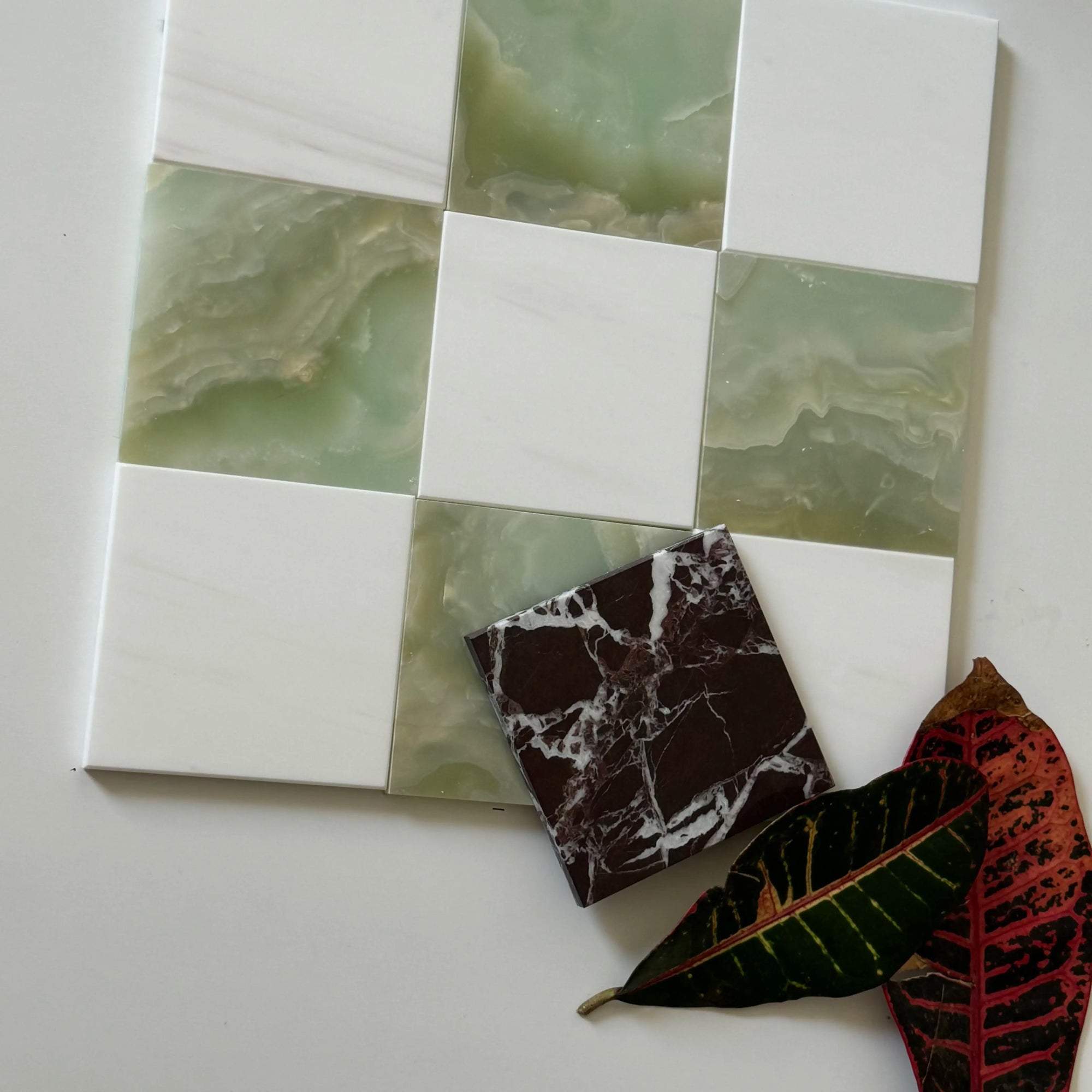 Checkerboard pattern with alternating Green Onyx and Bianco Dolomite tiles, accompanied by a small dark marble tile accent. The translucent green of the Onyx adds a soothing, natural touch to the sharp lines of the white marble. Ideal for statement walls and backsplashes