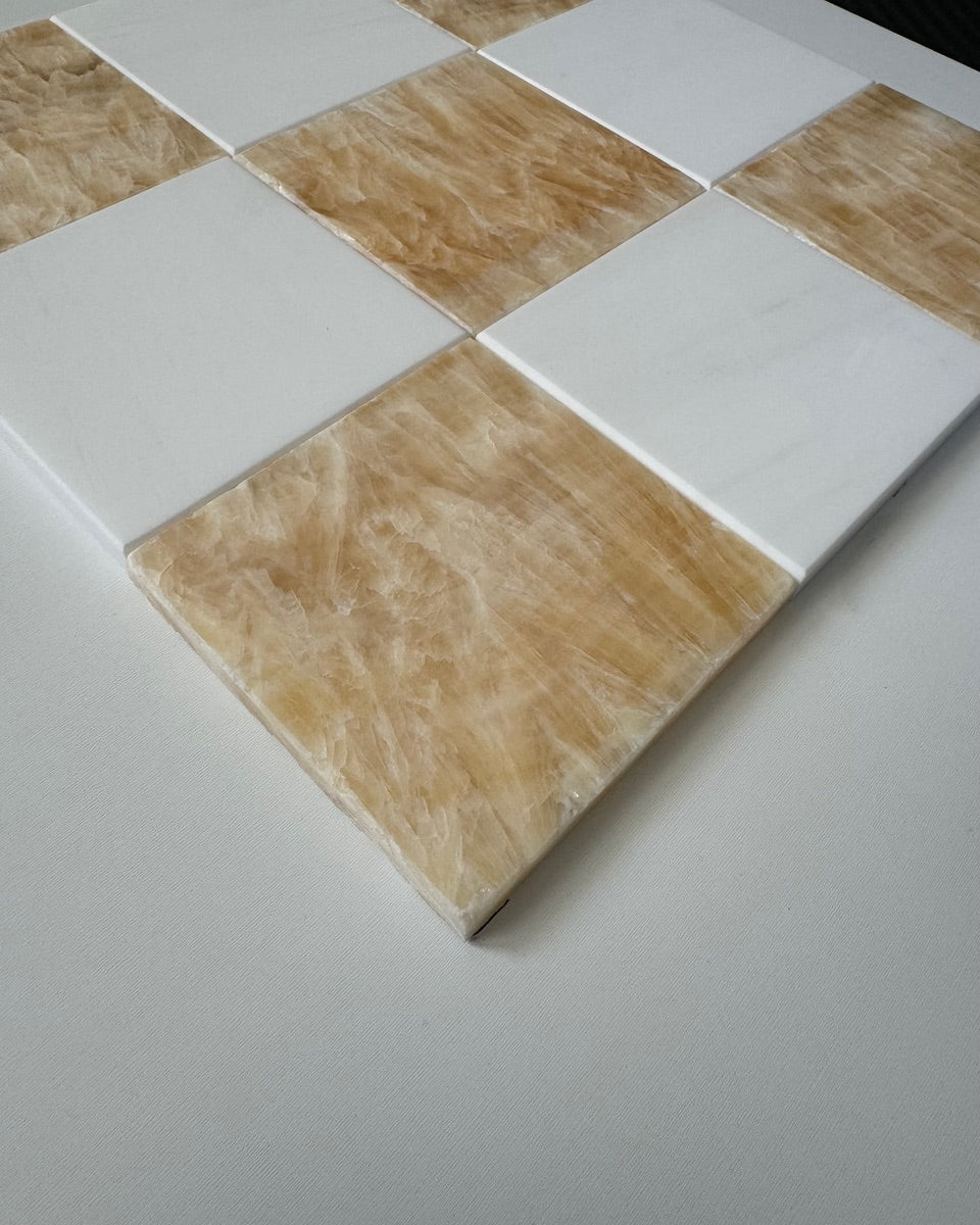 Checkerboard tile pattern featuring a blend of Honey Onyx and Bianco Dolomite tiles. The rich honey color paired with sleek white marble creates a sophisticated and warm aesthetic for both residential and commercial spaces.