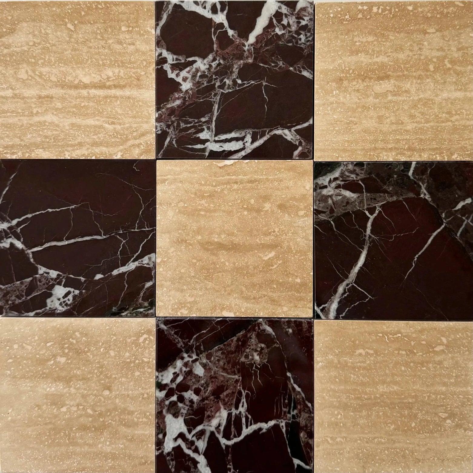 A close-up of luxurious Rosso Levanto marble’s intricate white veining combined with the subtle texture of vein-cut Roman Travertine. A beautiful blend of red marble and beige travertine for elegant checkerboard tile patterns.
