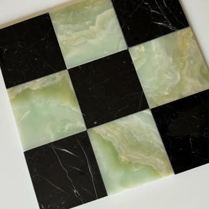 Checkerboard tile layout showcasing the blend of Nero Marquina black marble and translucent Green Onyx stone. This elegant combination of dark and light tones creates a visually striking effect, suitable for both residential and commercial spaces.