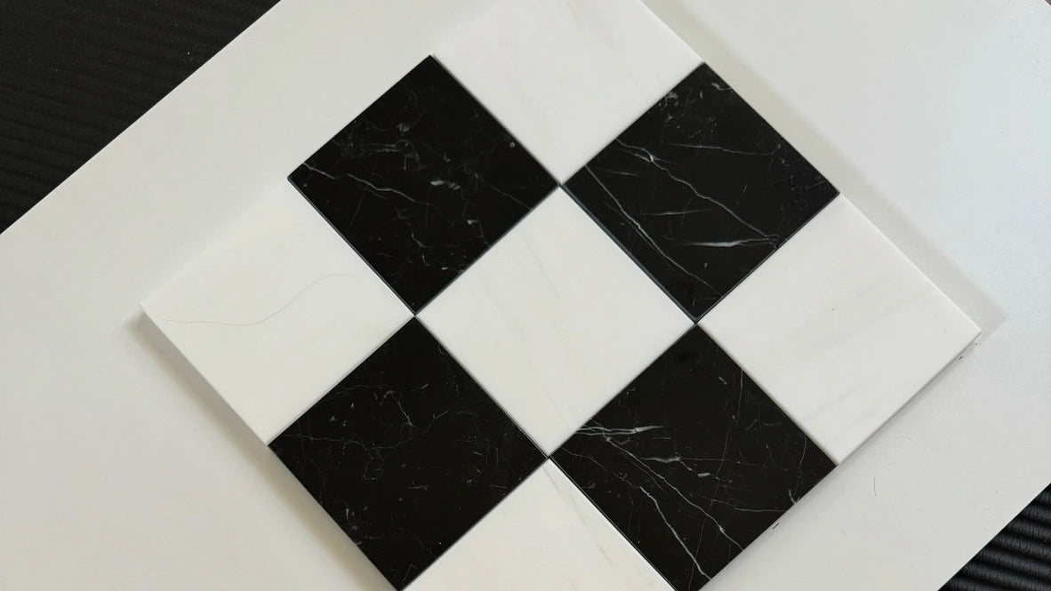 A checkerboard design featuring Nero Marquina black marble tiles contrasted with Bianco Dolomite white marble tiles. The black marble has white veining, adding texture to the striking black-and-white pattern, ideal for bold statement floors or walls.