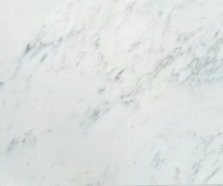 Oriental White marble, also known as Asian Statuary marble, with a polished finish. The soft white background is enhanced with gentle gray veining, offering a refined and classic look, ideal for creating luxurious floors, walls, and countertops in high-end interior designs within the tile and stone industry.