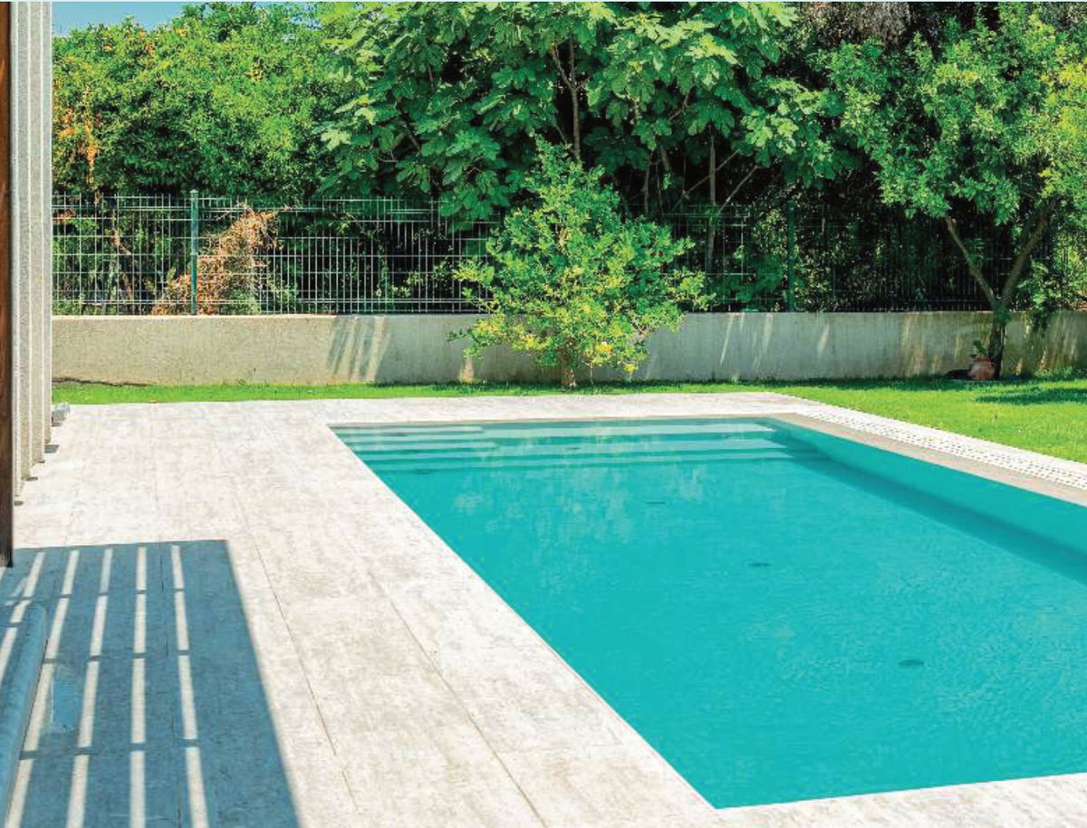 Silver Travertine porcelain pool deck tile around a residential pool, project example