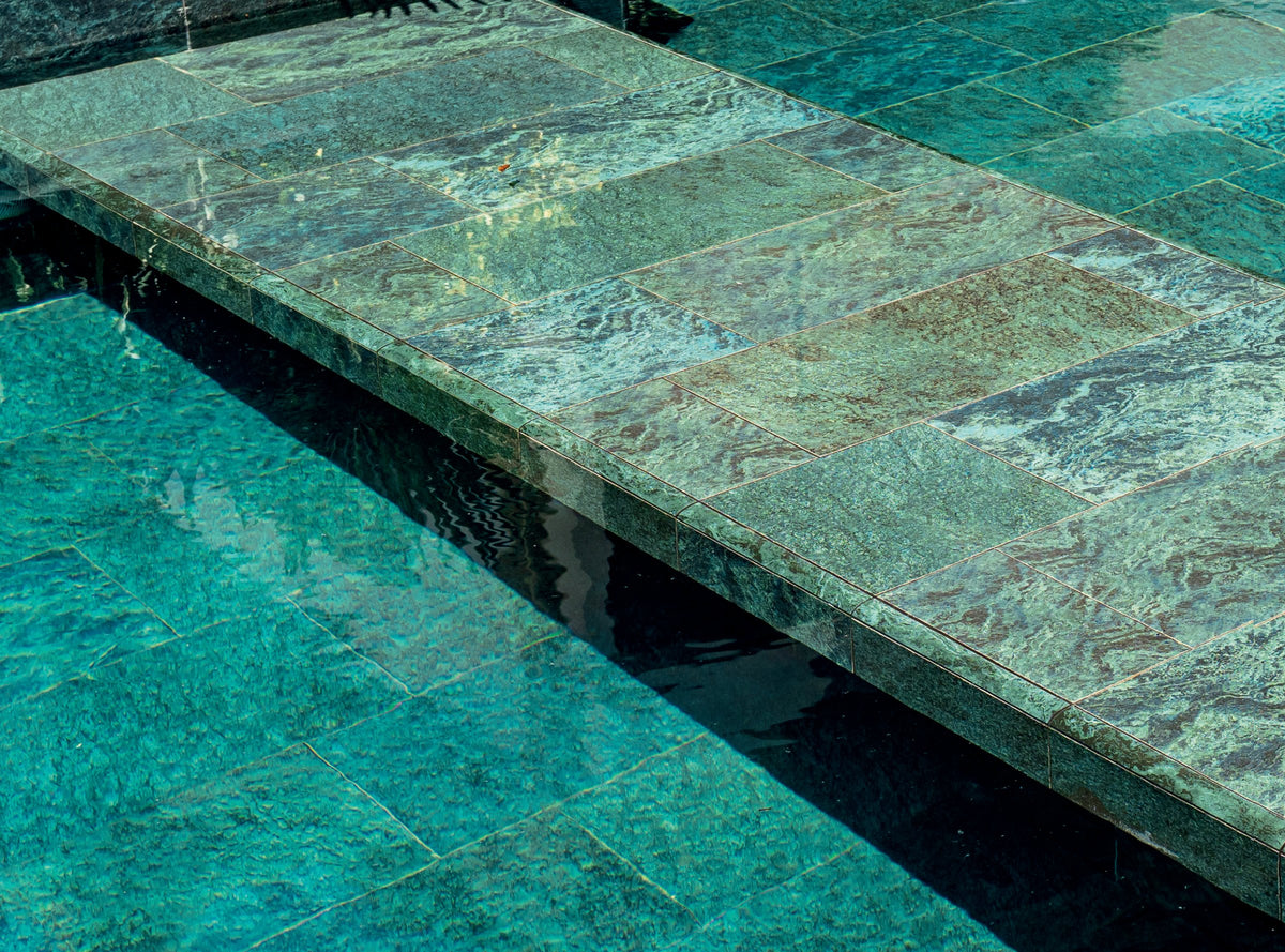 SeraPool Natural Verde Guatemala deep green porcelain pool tile installed in a villa pool with matching step and edge pieces